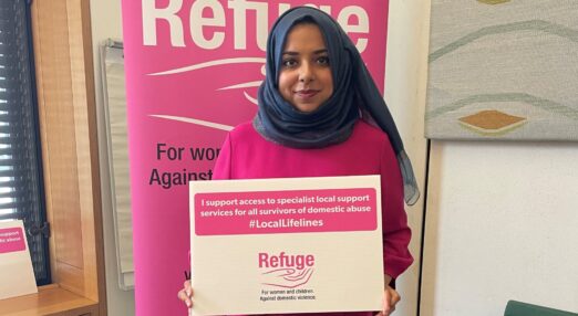 Woman holding a placard that reads "I support access to specialist local support services for all survivors of domestic abuse #LocalLifelines"