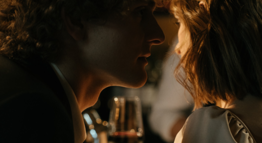 A man speaks into a woman's ear