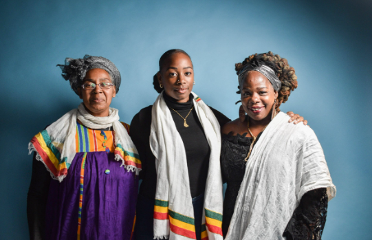 Three members of Sistah Space smiling at the camera with arms round each other