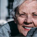 Grey haired woman looking directly into the camera.